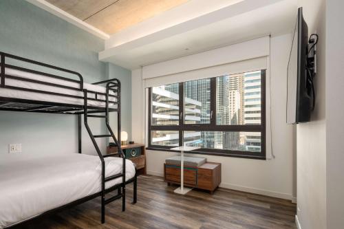 a bedroom with a bunk bed and a large window at Motto by Hilton Philadelphia Rittenhouse Square in Philadelphia