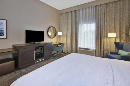 a hotel room with a bed and a desk and a television at Hampton Inn Kennebunk Kennebunkport Me in Kennebunk