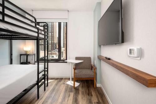 a bedroom with a bunk bed and a desk and a chair at Motto by Hilton Philadelphia Rittenhouse Square in Philadelphia