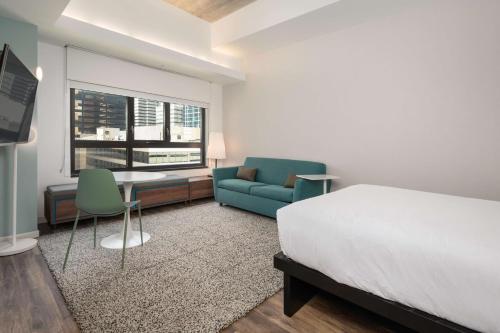 a bedroom with a bed and a desk and a couch at Motto by Hilton Philadelphia Rittenhouse Square in Philadelphia