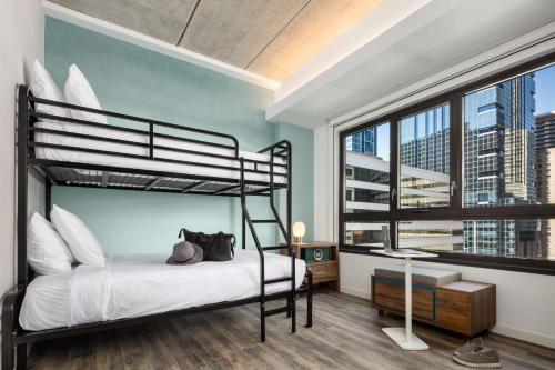 a bedroom with a bunk bed and a large window at Motto by Hilton Philadelphia Rittenhouse Square in Philadelphia