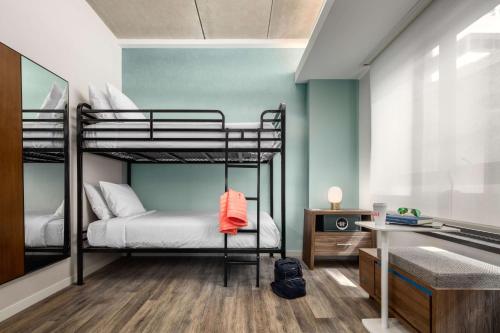 a bedroom with two bunk beds and a desk at Motto by Hilton Philadelphia Rittenhouse Square in Philadelphia