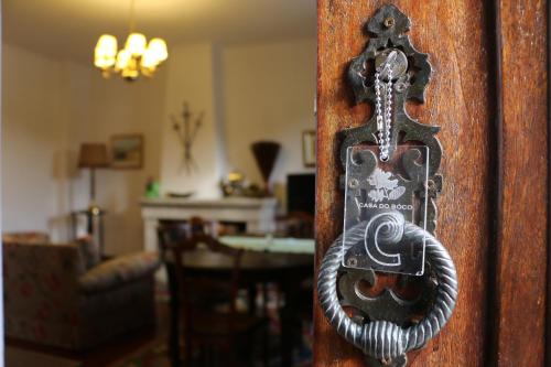 a metal door knocker on a wooden door at Casa do Boco in Oliveira do Hospital