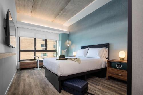 a bedroom with a large bed and a large window at Motto by Hilton Philadelphia Rittenhouse Square in Philadelphia
