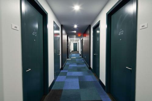 a hallway with blue doors and a tile floor at Motto by Hilton Philadelphia Rittenhouse Square in Philadelphia