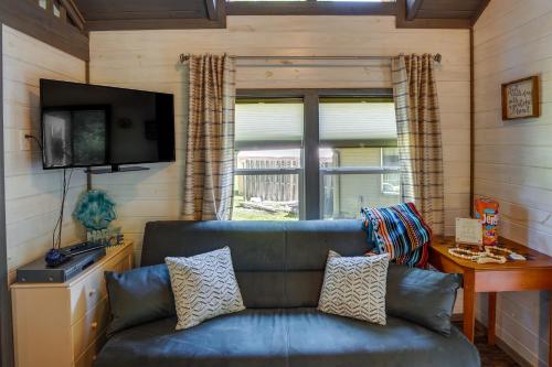 a living room with a couch and a television at Mayfield Tiny Home with Porch, Walk to Beaches! in Benson