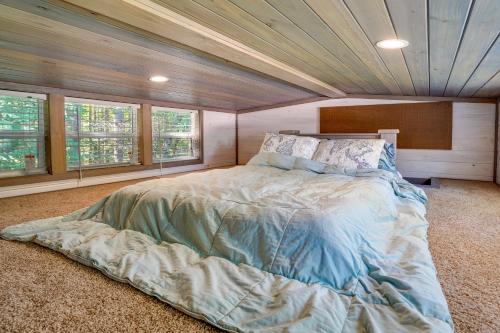 a bedroom with a large bed in a room with windows at Mayfield Tiny Home with Porch, Walk to Beaches! in Benson