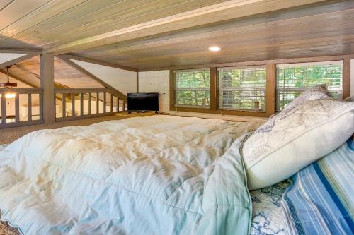 a large bed in a room with windows and a tv at Mayfield Tiny Home with Porch, Walk to Beaches! in Benson