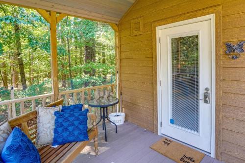 a porch with a bench and a table and a door at Mayfield Tiny Home with Porch, Walk to Beaches! in Benson