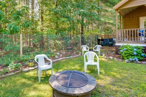 three chairs and a table in a yard at Mayfield Tiny Home with Porch, Walk to Beaches! in Benson