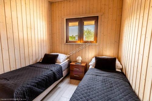 two beds in a room with a window at Domek letniskowy in Władysławowo