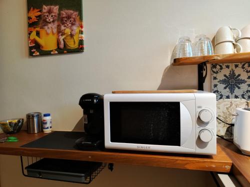 a microwave sitting on top of a table at Guestroom Happynest no.3 in Melíssia