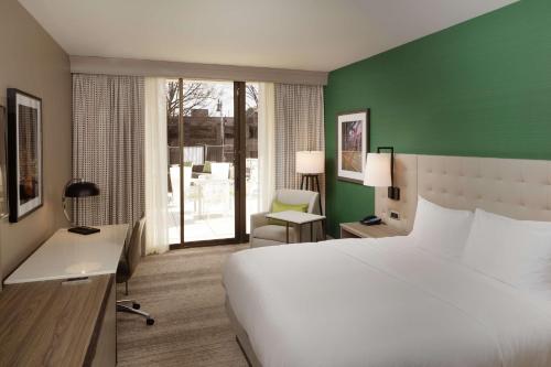 een slaapkamer met een wit bed en een groene muur bij Hilton Birmingham Downtown at UAB in Birmingham