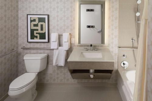 a bathroom with a toilet and a sink and a mirror at Hilton Birmingham Downtown at UAB in Birmingham