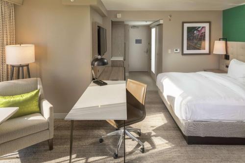 a hotel room with a bed and a desk and a chair at Hilton Birmingham Downtown at UAB in Birmingham