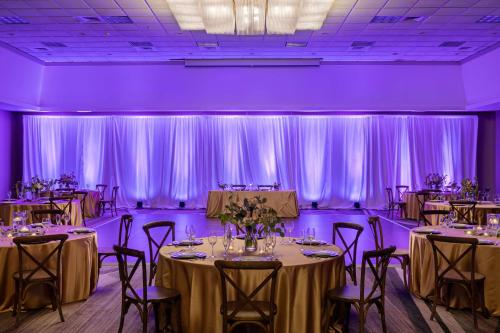 a room filled with tables and chairs with purple lighting at Hilton Birmingham Downtown at UAB in Birmingham
