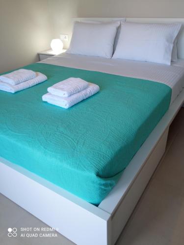 a bed with two towels on top of it at Orange apartment in Zaros