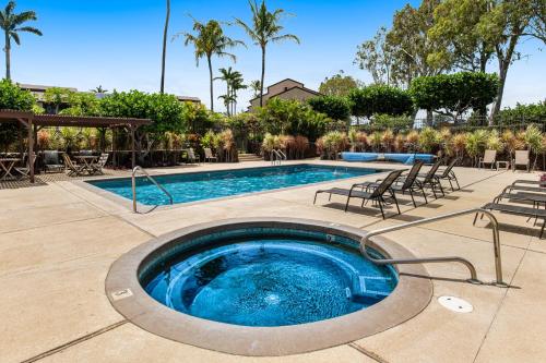 a swimming pool with chairs and a table at Waikoloa Villas #H202 in Waikoloa