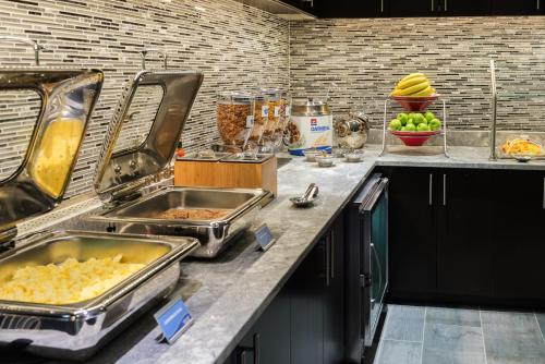 a kitchen with two sinks and some food on a counter at Fairfield Inn & Suites by Marriott Boston Cambridge in Cambridge