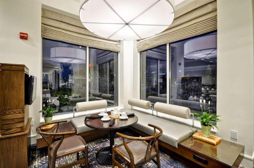 a living room with a table and chairs and a large window at Hilton Garden Inn Detroit Troy in Troy