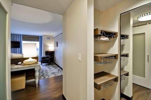 a room with a hallway with a mirror and a desk at Hilton Garden Inn Detroit Troy in Troy