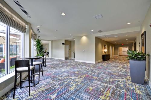 a lobby with chairs and a bar in a building at Hilton Garden Inn Detroit Troy in Troy