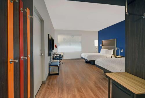 Habitación de hotel con 2 camas, mesa y sillas en Tru By Hilton Troy Detroit, Mi en Troy