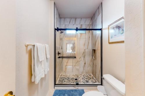 La salle de bains est pourvue d'une douche avec une porte en verre. dans l'établissement Vistoso Resort Casita #153, à Oro Valley