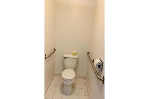 a bathroom with a toilet and a roll of toilet paper at Economy Inn of Holland in Holland