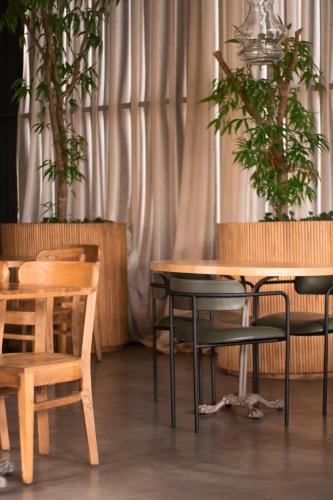 a table and chairs in a room with potted plants at The Art Hotel Medellin in Medellín