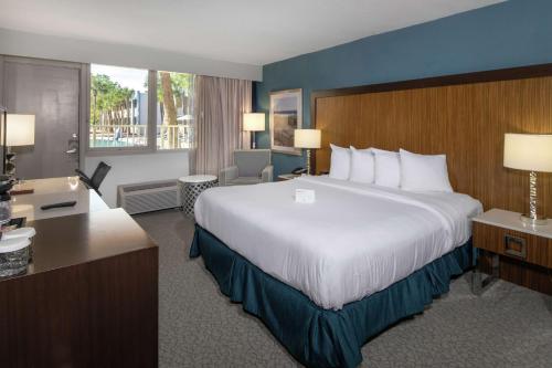 um quarto de hotel com uma cama grande e uma secretária em DoubleTree by Hilton Hotel Jacksonville Airport em Jacksonville