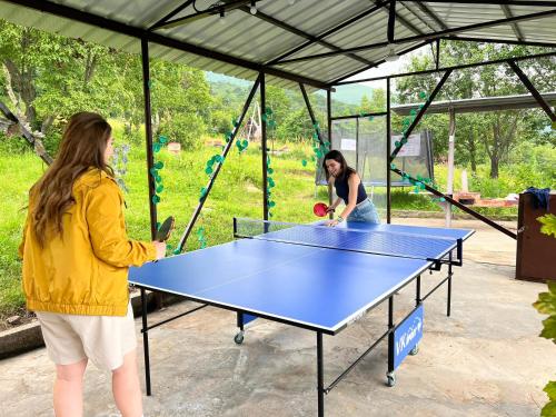 two women playing a game of table tennis in a tent at GLAMPING WOLF MOUNt in Margahovit