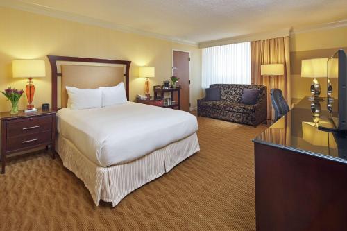 um grande quarto de hotel com uma cama e um sofá em Hilton Raleigh North Hills em Raleigh