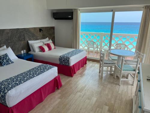 a hotel room with two beds and a view of the ocean at OVA Apartments Cancun in Cancún