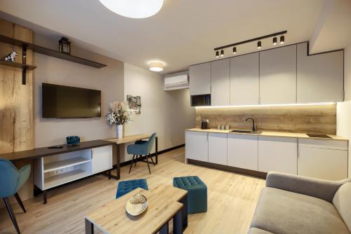 a kitchen and living room with a couch and a table at AboutArtApartments - Otyńska 4 in Wrocław