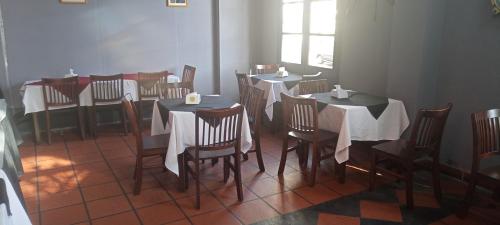 una sala da pranzo con tavoli, sedie e una finestra di Hotel Beltran a Colonia del Sacramento