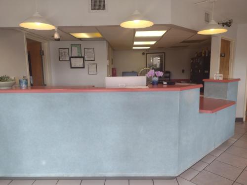 a lobby with a reception counter with flowers at Wind Chase Inn in Loxley