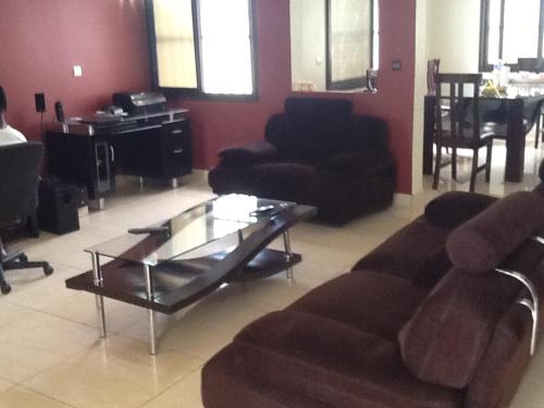 sala de estar con 2 sofás y mesa de cristal en Villa meublée 4 chambres Agodekè, en Lomé