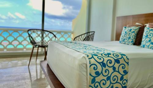 a bedroom with a bed and a table and chair at OVA Apartments Cancun in Cancún
