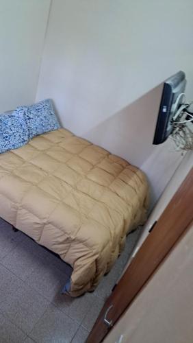 una cama en una esquina de una habitación en Simple y cálido departamento en Maipú