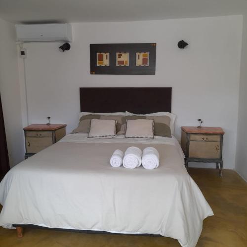 1 dormitorio con 1 cama blanca y 2 mesitas de noche en Bella Vista en Valle Hermoso