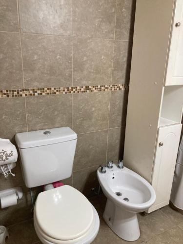 a bathroom with a white toilet and a sink at Portales I in Santa Fe