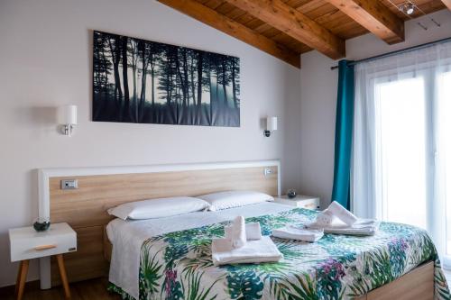 1 dormitorio con 1 cama con toallas en Il Beccaria Relais B&B, en Fondi
