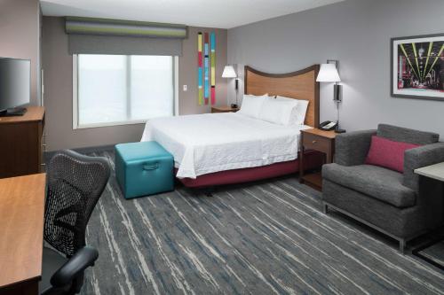 a hotel room with a bed and a chair at Hampton Inn & Suites Chicago North Shore in Skokie