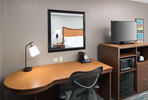 a room with a desk with a television and a mirror at Hampton Inn & Suites Chicago North Shore in Skokie