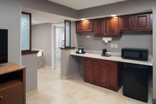 a kitchen with wooden cabinets and a microwave at Hampton Inn & Suites Chicago North Shore in Skokie
