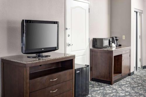 a room with a television on a dresser with a counter at Hilton Garden Inn Cincinnati/Mason in Mason