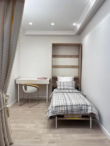 un dormitorio con una cama y un escritorio en NERIS Apartments, en Vilna
