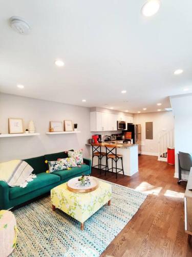 a living room with a green couch and a table at Charming 1BDR In Central Rittenhouse Square With Patio Hosted by StayRafa in Philadelphia