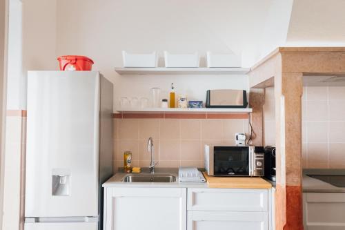 a small kitchen with a sink and a microwave at Dear Faro - Guest House in Faro